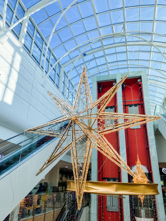 A remarkably large star is gracefully hanging from the ceiling of a beautifully designed building,...