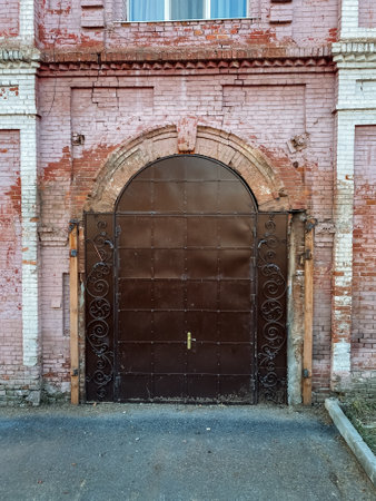 The structure in question is a beautiful brick building that prominently features a brown door along with a window, embodying classic architectural elements that reflect its timeless designの写真素材