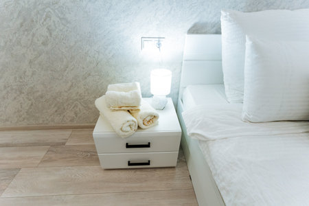 This cozy bedroom features a comfortable bed for restful sleep and an elegant nightstand with neatly...