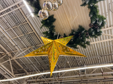 A stunningly bright yellow star is elegantly hanging from the ceiling of an expansive building, greatly enhancing the charm and vibrancy of the interior space, making it feel more inviting and livelyの写真素材