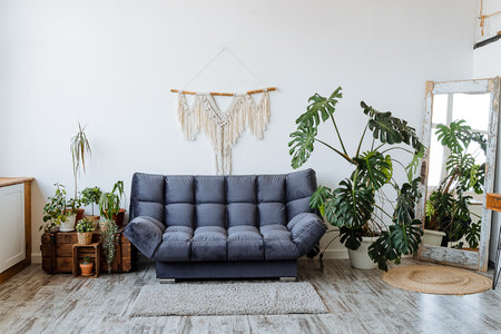 The living room features a cozy couch for relaxation, vibrant green plants for a refreshing touch, and a stylish mirror that enhances the tranquility and aesthetic appeal of the spaceの写真素材