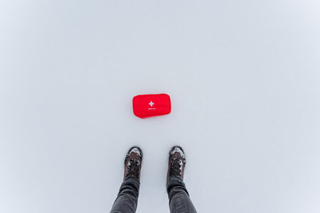 A person is standing outside in the cold snow beside a bright red box, enjoying the winter scenery. The air is freezing and the ground is covered in a thick layer of white precipitationの写真素材