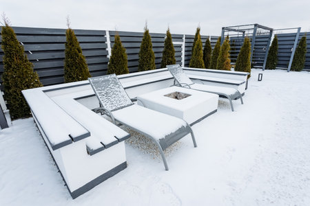 Envision a stunning patio that boasts a cozy fire pit at its center, encircled by chairs that are...