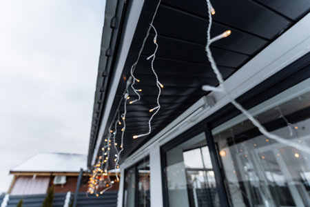 Beautiful and colorful Christmas lights elegantly hang down from the ceiling of a cozy and warm house, creating a festive and cheerful atmosphere for everyone during this joyful holiday seasonの写真素材