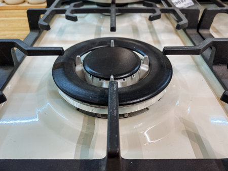This image features a closeup of a modern gas cooktop burner with a stylish control knob and robust metal grates, inspiring kitchen design while showing the beauty of modern cookwareの写真素材