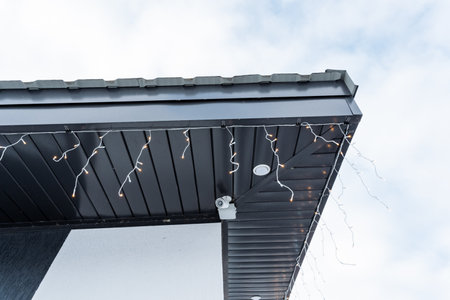 A charming house roof beautifully adorned with vibrant Christmas lights creates a warm and inviting...