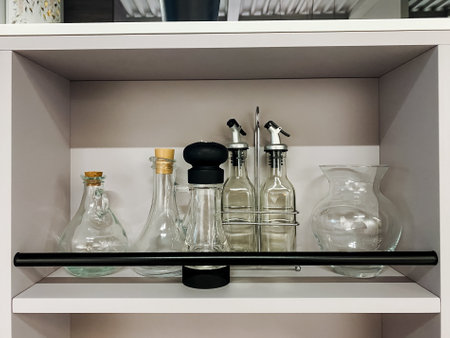 A beautifully arranged shelf that features a variety of stylish bottles and elegant vases artfully placed on it, significantly enhancing the overall aesthetic appeal of the rooms interior designの写真素材