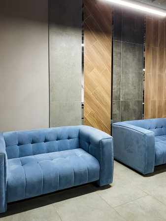 In a cozy living room, two beautiful blue couches are positioned right next to each other, creating an inviting and comfortable space for relaxation and conversation with family and friendsの写真素材