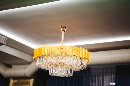 A large, beautifully designed chandelier is elegantly hanging from the ceiling of the room, adding...