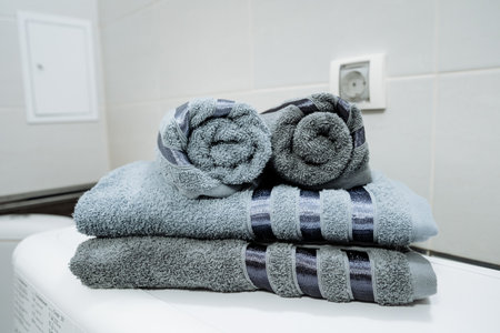 A neat stack of colorful towels carefully arranged on top of each other, placed on a pristine bathroom counter, ready for use or display for guests to admire and utilize as neededの写真素材