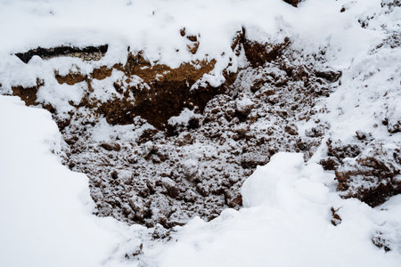 A distinctly noticeable pile of dirt, artfully mixed with freshly fallen snow, creates a striking contrast, reflecting the chilly winter season that were currently experiencing togetherの写真素材