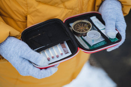 Essential Adventure Kit A collection of Survival Tools and a reliable Compass specifically designed for Outdoor Enthusiasts exploring in a snowy landscape and environmentの写真素材