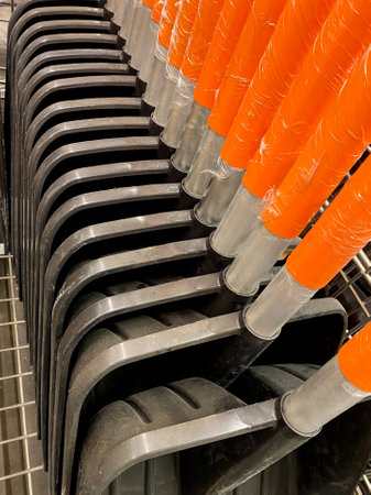 A collection of several shovels, each exhibiting vibrant orange handles, are meticulously stacked...