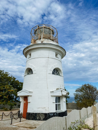 A breathtaking white lighthouse stands tall against a vibrant, clear blue sky, creating a mesmerizing contrast that captivates all who gaze upon it, inspiring a sense of adventure and explorationの写真素材