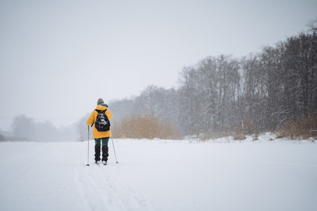 An enthusiastic person enjoys a thrilling crosscountry skiing adventure, skillfully navigating the beautiful, untouched snowcovered landscape of the picturesque winter wonderlandの写真素材