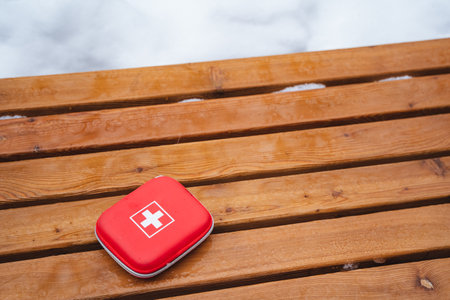 On a sturdy wooden table that showcases its beautiful natural grain and texture, a bright red first...
