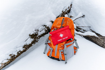 A practical backpack that contains a wellstocked first aid kit is resting on a blanket of soft white snow, ready for any emergencies or injuries that may occur in this cold, winter environmentの写真素材