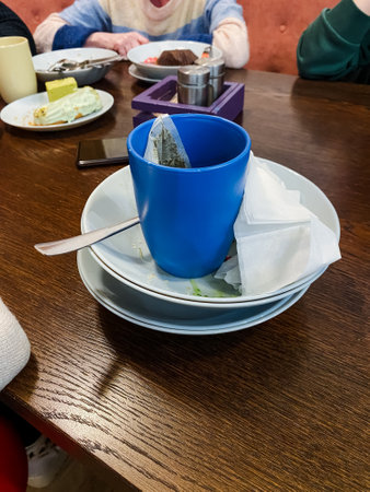 There is a charming blue cup that is elegantly perched on top of a neatly organized stack of various...