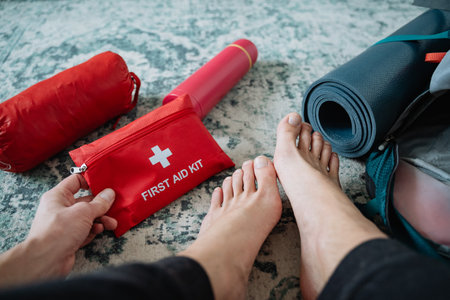 A person is standing with a first aid kit placed at their feet, which is essential for ensuring...