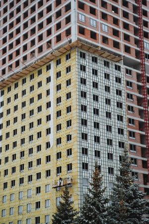 A very tall building is currently under construction and features a significant number of windows across its facade, indicating its potential to become a modern architectural landmarkの写真素材