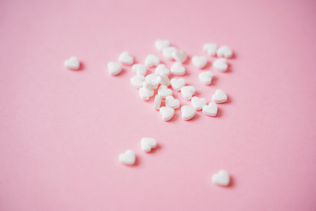 A pile of white hearts on a pink background