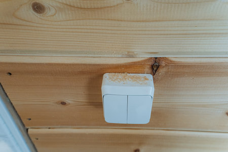 A white light switch is mounted on the wooden wall, adding warmth and character to the room,...