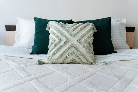 In a cozy and inviting bedroom, there is a wonderfully comfortable bed adorned with a soft, fluffy...