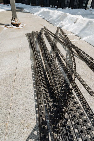 A diverse array of various metal pieces is scattered across the uneven ground, creating an...