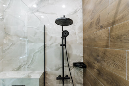 This charming bathroom features an elegant black shower head positioned against a rustic wooden...