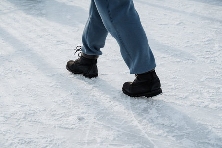 A person strolls gracefully on fresh, untouched snow, wearing stylish winter attire paired with cozy boots, perfectly suited for enjoying the cold weather and engaging in outdoor adventuresの写真素材