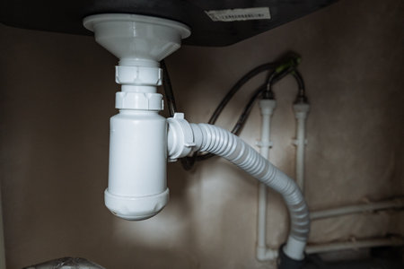 A close up of a sink drain with a hose attached to it. High qualityの写真素材