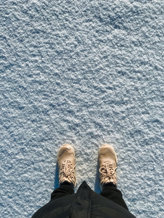 A person is standing in a deep blanket of fresh, white snow while wearing a sturdy and reliable pair...