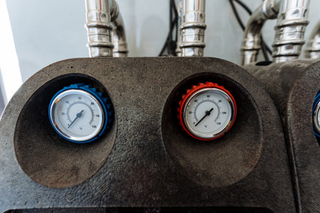 The image shows two precision pressure gauges on an industrial machine, crucial for monitoring and...