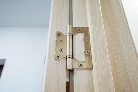 This image features a detailed closeup of a door hinge on a beautifully crafted wooden door, showcasing its intricate design and craftsmanship, embodying both functionality and styleの写真素材