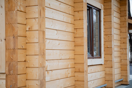 There is an appealing wooden house featuring a quaint window located on the side, adding character...