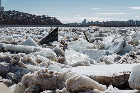 A substantial and sizeable pile of ice is currently resting on the shore of a lake, glimmering under the winter sun. The icy formation showcases the beauty of the chilly seasonの写真素材