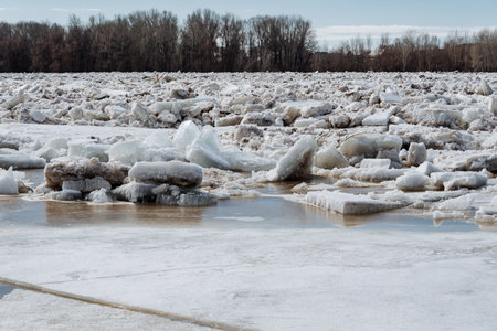 A vast expanse of water that is completely blanketed in thick layers of ice and fluffy snow, with...