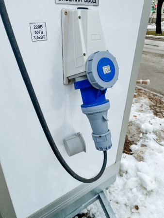 A blue plug is securely attached to a clean white wall, ensuring that electrical connections are...