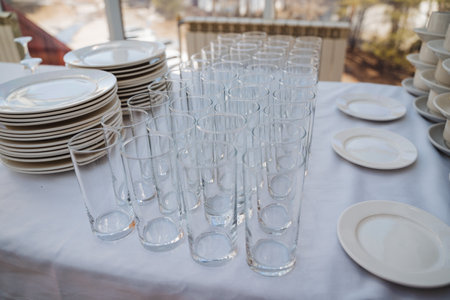 A beautifully set table features an impressive and diverse array of plates, glasses, and exquisite tableware, all elegantly displayed to create a warm and inviting atmosphere for guestsの写真素材