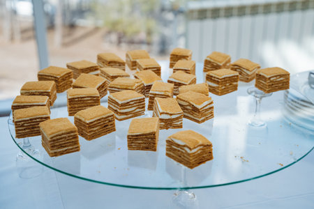 A glass plate delicately filled with an assortment of small, delectable pieces of cake, perfect for serving during any gathering or celebration. Ideal for anyone who enjoys delightful dessertsの写真素材