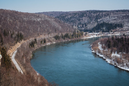 An impressive aerial view showcases a serene river that is beautifully surrounded by majestic...