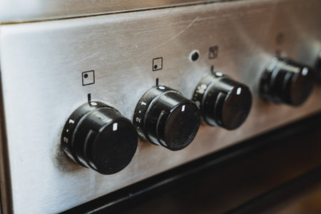 This closeup image showcases a contemporary stove with elegant black knobs, highlighting its stylish design and practical features that enhance the kitchens attractiveness and functionalityの写真素材