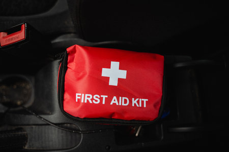 A bright red first aid kit that features a prominent white cross symbol is specifically designed for emergencies and various health needs, making it an ideal choice for both vehicles and homes alikeの写真素材