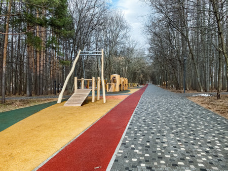 Imagine a vibrant playground with colorful surfaces and welldesigned equipment, nestled beside a peaceful pathway lined with trees, ideal for families to enjoy outdoor fun togetherの写真素材