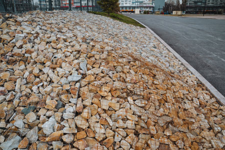 A substantial and wellstructured pile of gravel has been strategically positioned near a busy road,...