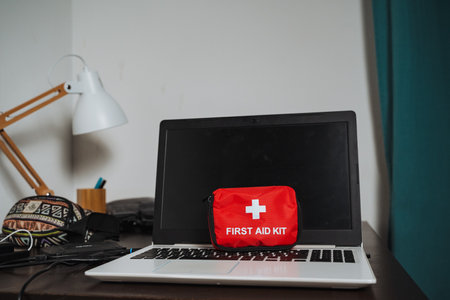 A first aid kit on a laptop symbolizes the essential integration of health and technology in our...