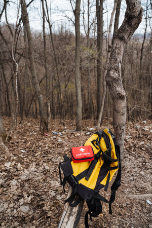 A bright yellow backpack is casually leaning against a sturdy and strong tree deep within the serene...