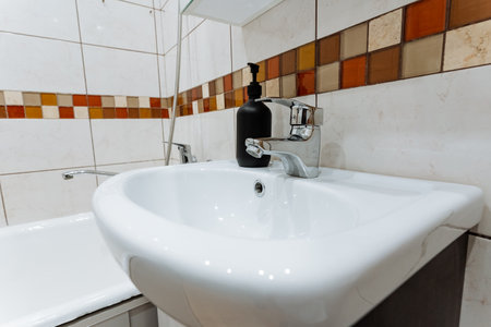 A bathroom sink with a soap dispenser on top of itの写真素材