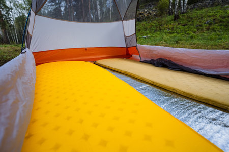 A warm and inviting interior view of a camping tent showcasing two colorful sleeping pads, which are perfect for enjoying outdoor adventures and creating lasting memories in natures embraceの写真素材