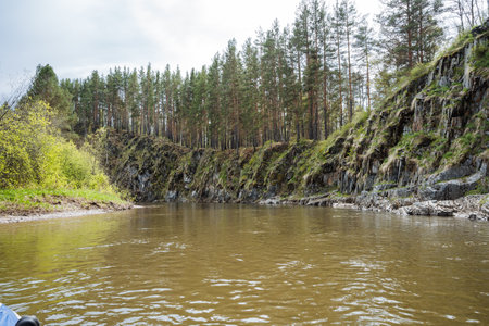 A serene river flows through a picturesque landscape of steep cliffs and lush greenery, making it an ideal getaway for nature lovers and adventurers seeking escape from everyday lifeの写真素材
